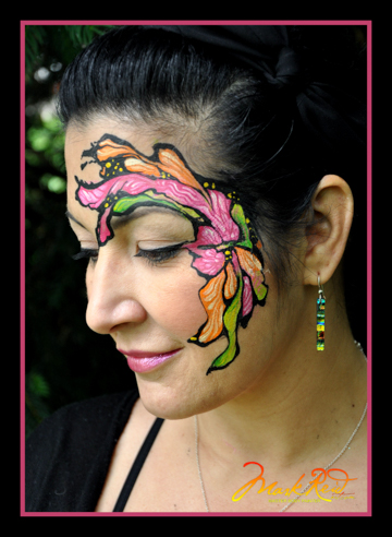 woman with a face painting around her left eye that is colorful